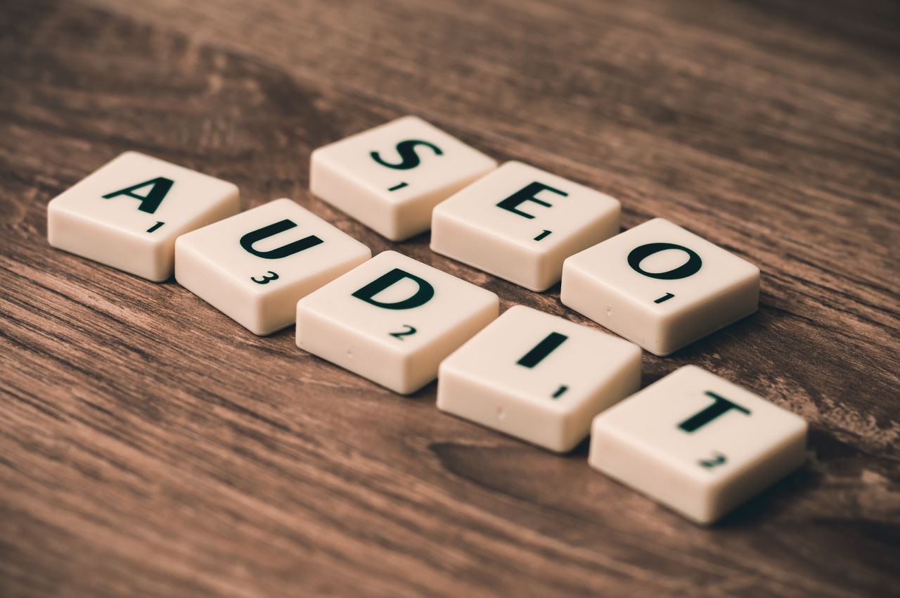 services-01 Scrabble tiles spelling SEO Audit on wooden surface, symbolizing digital marketing strategies.